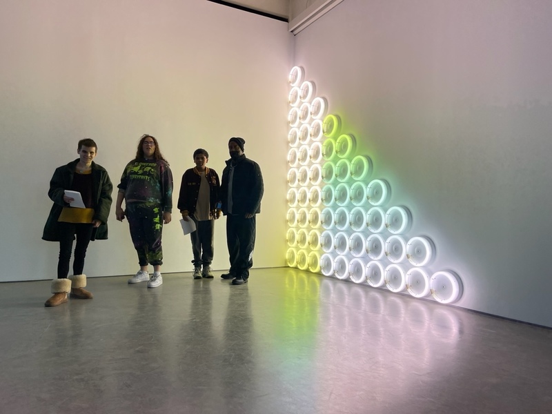 Students pose in front of a light exhibit